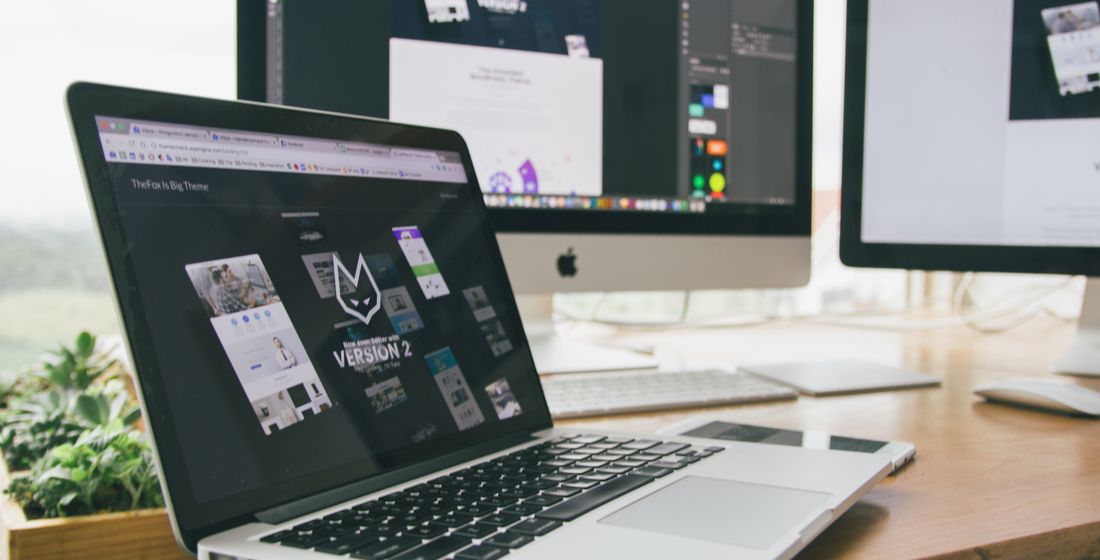 Website designs on a laptop and desktop monitors